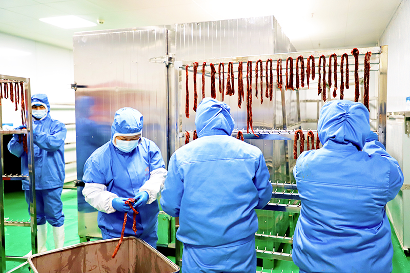 贵州犇竔焱食品有限责任公司的数控烘干室内，数名工人正在作业.JPG